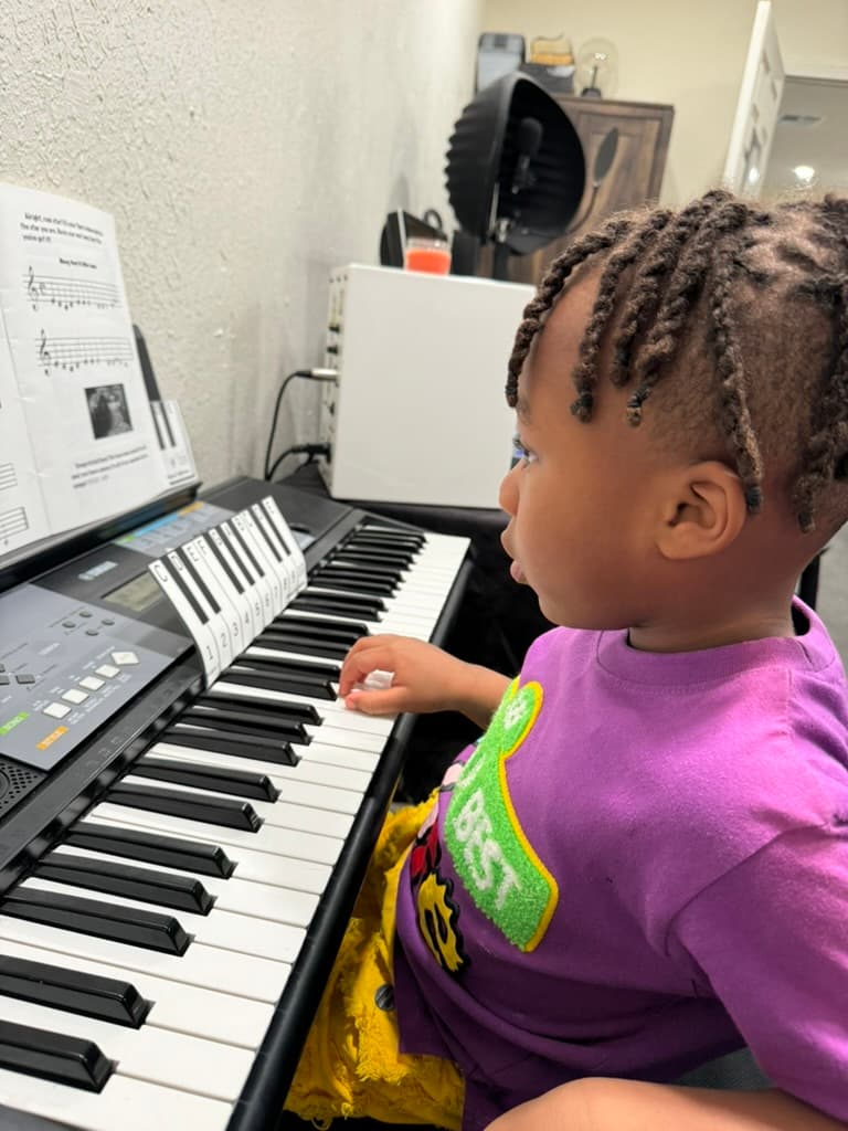 Young METLC student practicing at a keyboard.